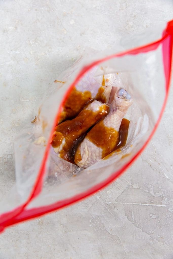 ziplock bag with raw chicken legs and teriyaki sauce inside