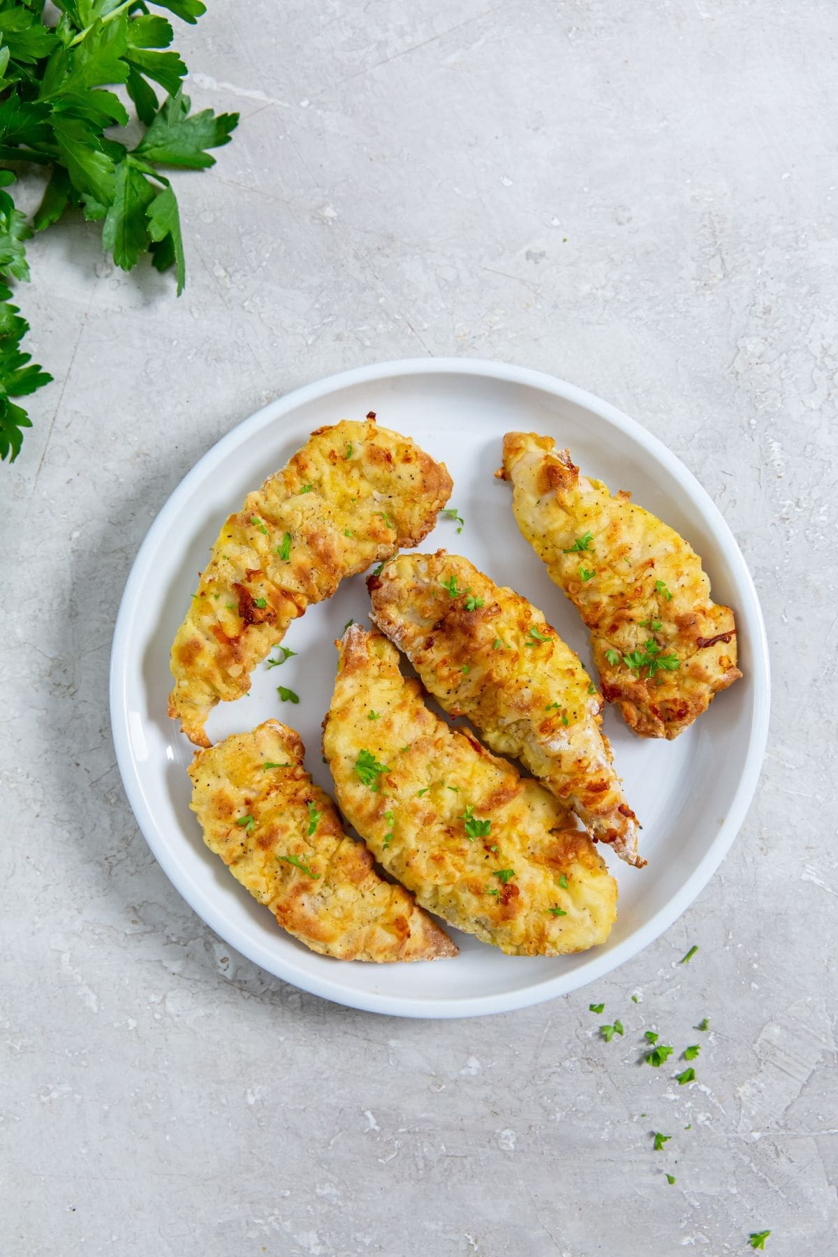white plate with chicken parsley in the back