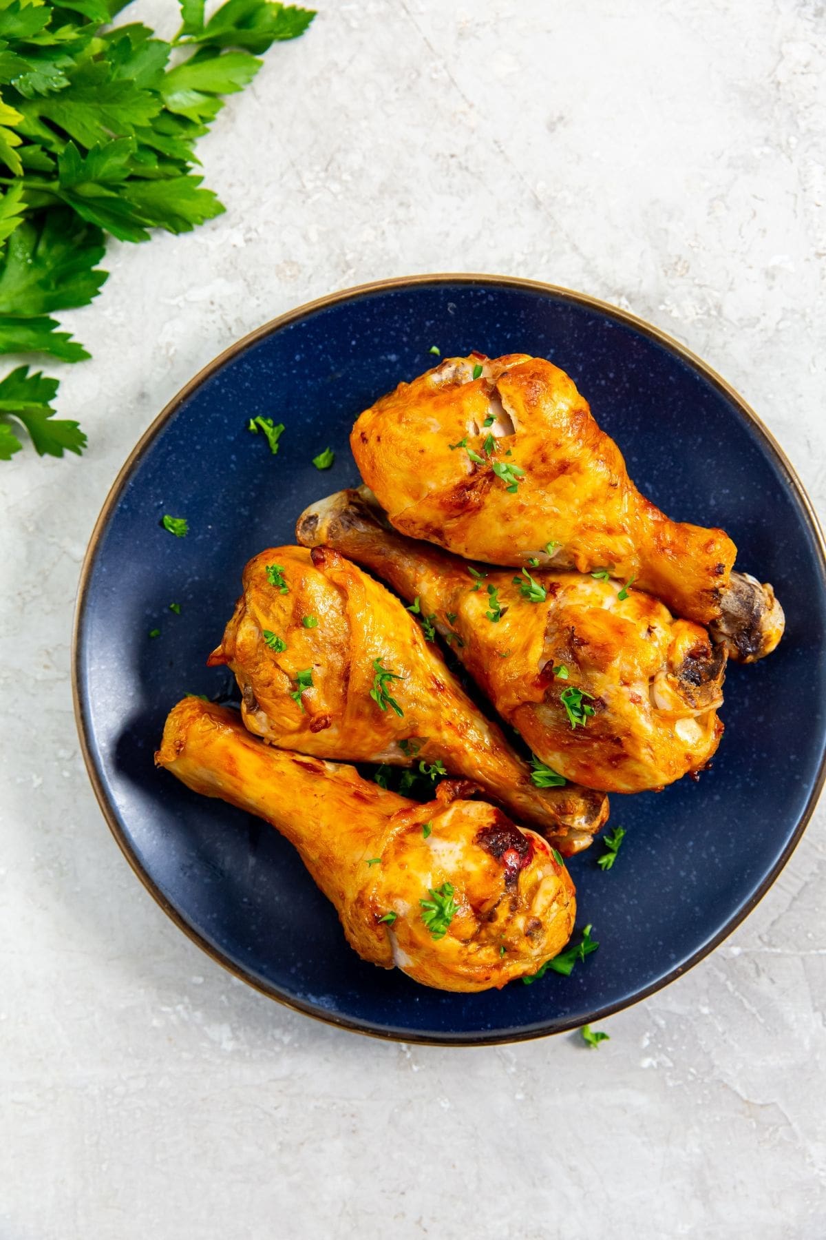 blue plate with chicken and parsley in the back