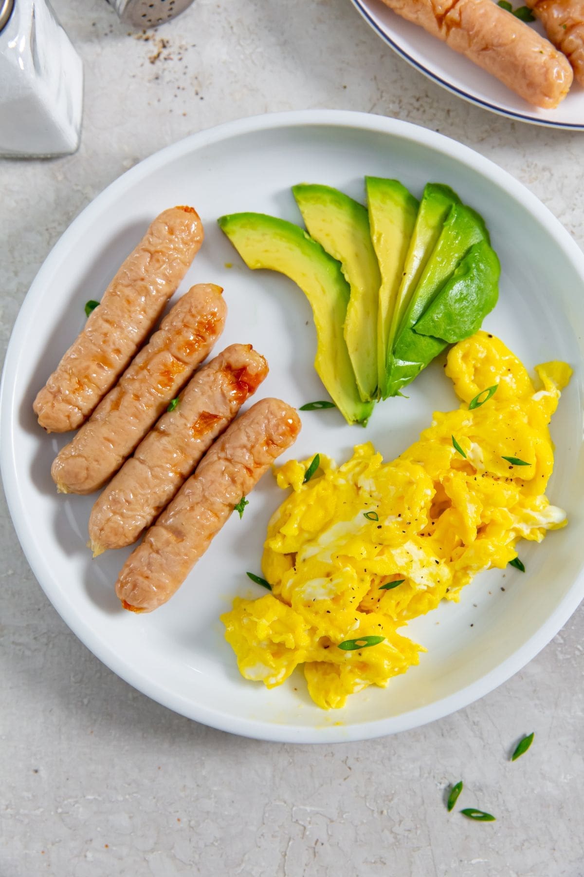 Air Fryer Trader Joe's Chicken Breakfast Sausage with eggs, and avocado slices.