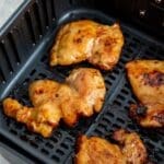 paleo teriyaki chicken thighs in an air fryer basket.