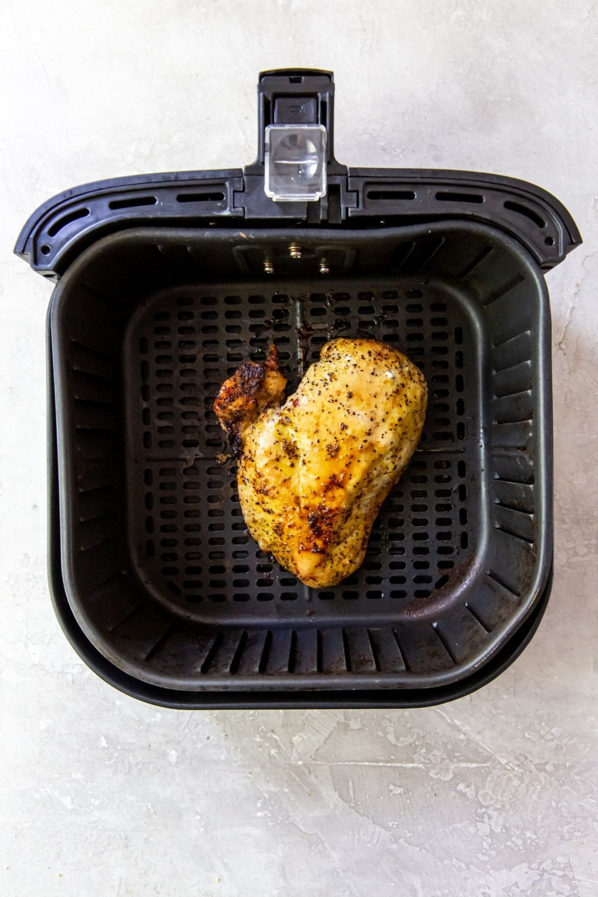 An air fryer perfectly cooking chicken breasts.