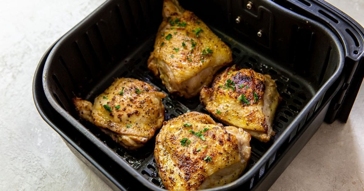 Chicken Air Fryer Recipes Delivery Can’t Compete With Close Up of an Air Fryer Basket Filled with Air Fryer Lemon Pepper Chicken Thighs