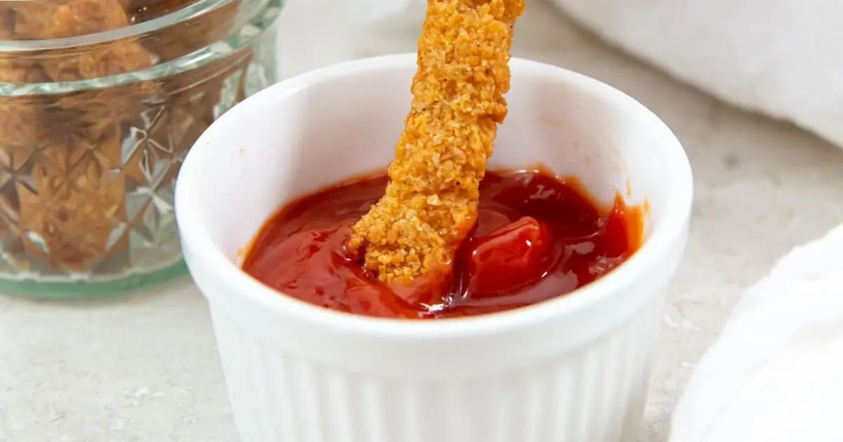 Best Chicken Air Fryer Snacks for Kids Tyson Chicken Fries in the Air Fryer Being Dipped into a Small Ramekin of Ketchup