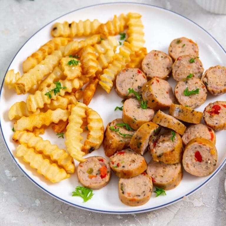 Air Fryer Chicken Sausage Recipes Close Up of a Plate of Cut Up Sausages with Crinkle Cut Fries