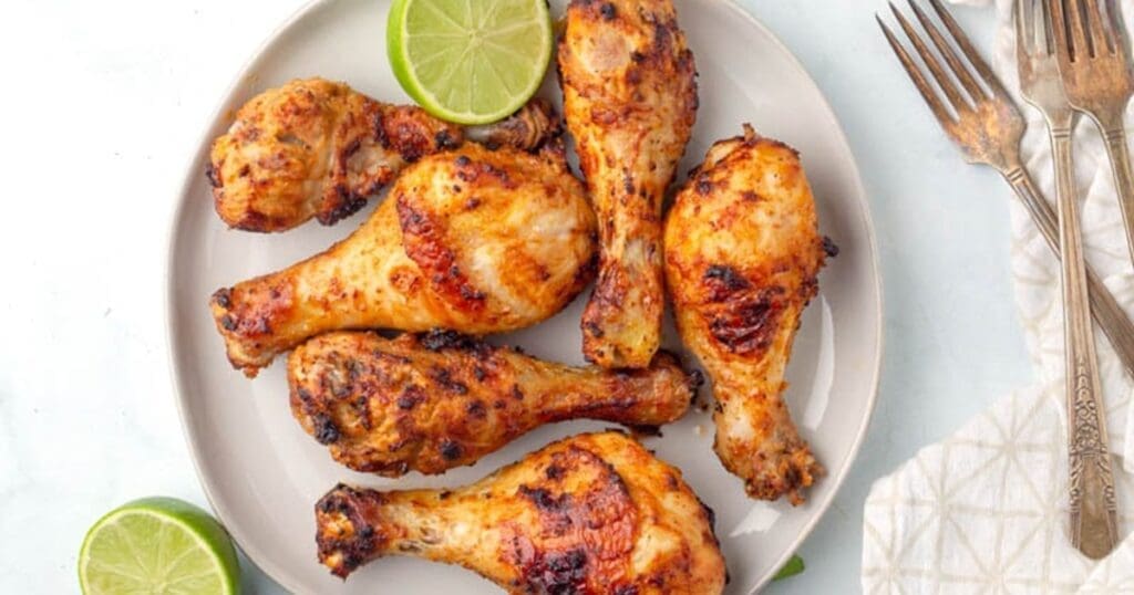 Chicken Legs in Air Fryer Recipes Close Up of Garlic Lime Air Fryer Chicken Legs on a Plate with Half a Lime